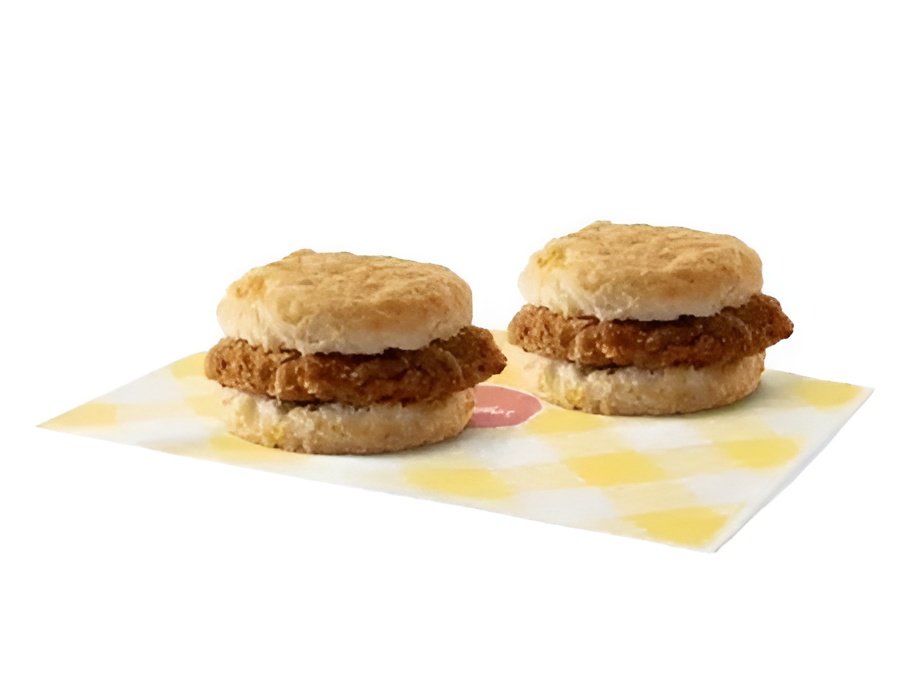 two Bojangles Steak Biscuits on a white plate with a dipping sauce cup